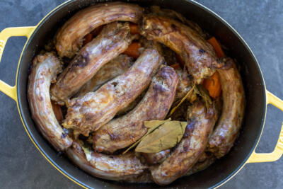 Cooked Turkey Necks in a pan.
