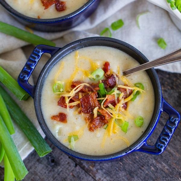 creamy potato soup in a bowl with bacon cheese and green onions