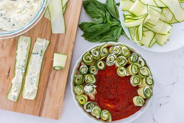 Lasagna Roll ups in a plate and rolls being made