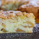 A slice of apple cake with powdered sugar