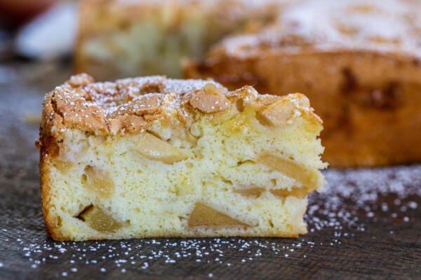 A slice of apple cake with powdered sugar