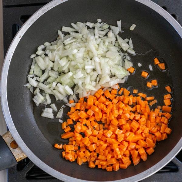 carrots and onions cooking in a skillet