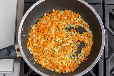 carrots and onions cooking in a skillet