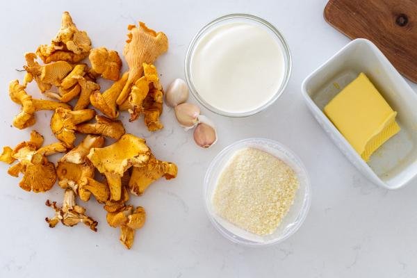 Hands cleaning chanterelle mushroom with pastry brush