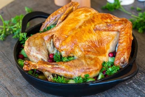 Roasted turkey in a pan with herbs
