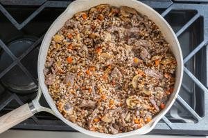 Skillet with beef, carrots, onion and mushroom