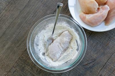 flour and seasoning over chicken
