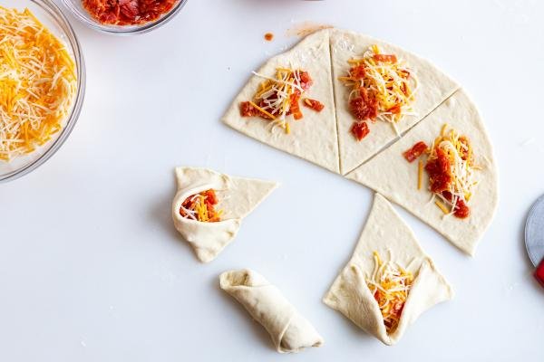 pizza rolls on a counter, halfway rolled up