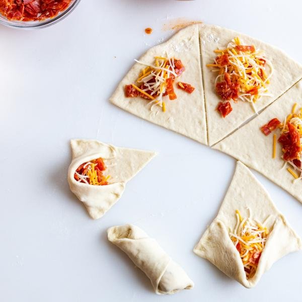 pizza rolls on a counter, halfway rolled up