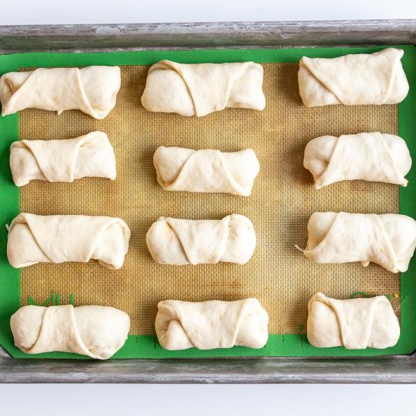 Unbaked pizza rolls on a baking sheet