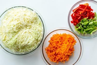 cabbage, carrots and peppers in bowls