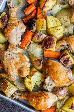 chicken and potatoes on a baking sheet