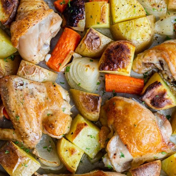 chicken and potatoes on a baking sheet