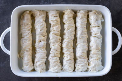Rolled Bucklava in a baking dish.