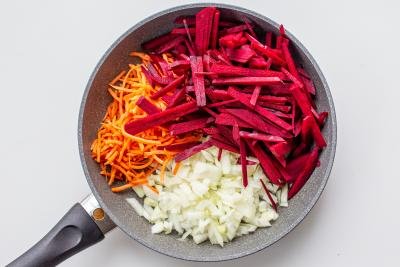 Beets, carrots and onions cooking on a skillet