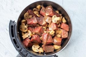Uncooked steak and mushrooms in a basket