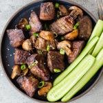Air fryer steak bites in on a plate with cucumbers