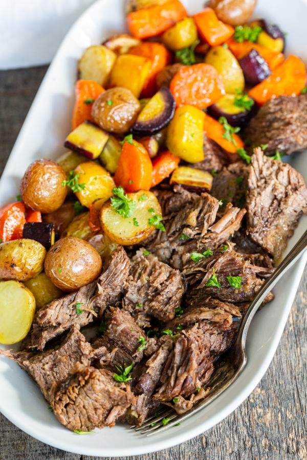 a serving plate with beef and carrots with potatoes
