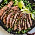 Sliced carne asada on the grilling pan with cilantro
