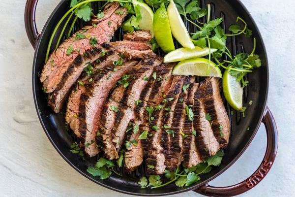 Sliced carne asada on the grilling pan with cilantro