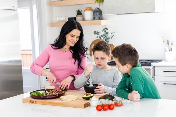 mom and two kids cooking together