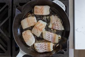 cod in a frying pan with butter