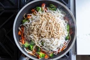 Noodles and sauce added to a skillet