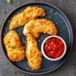 Air fryer chicken tenders on a plate with ketchup