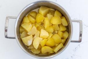 A cooking pot with potatoes and cream