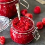 Raspberry Jam in a Jar with berries around
