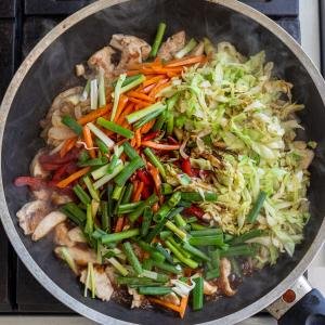 vegetables, sauce and chicken in a skillet