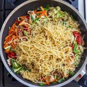 noodles in a skillet with veggies and chicken