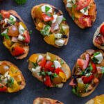 Bruschetta on a tray with tomatoes and basil