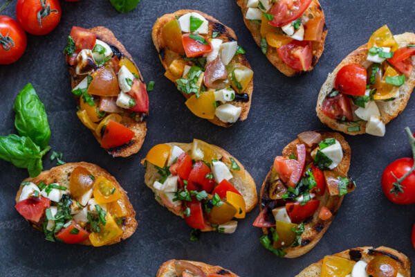  Bruschetta en una bandeja con tomates y albahaca