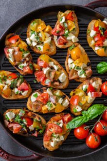 Bruschetta on a tray with tomatoes and basil