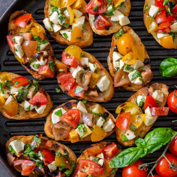 Bruschetta on a tray with tomatoes and basil