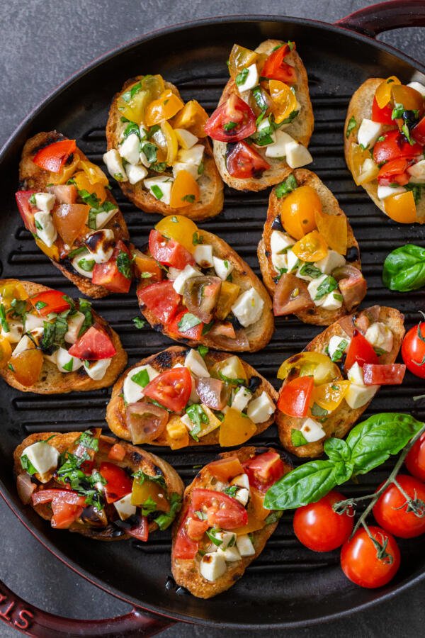 Bruschetta em uma bandeja com tomate e manjericão