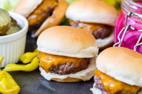 A pile of sliders with pickled veggies