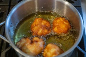 apple fritters in a pot with oil