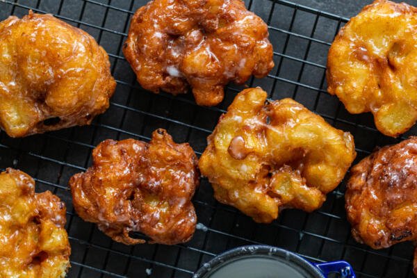 Apple Fritters on a cooling rack with glaze