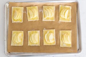 Raw apple tarts on a baking sheet