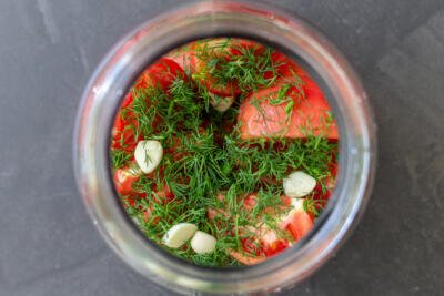 tomatoes and herbs in a jar