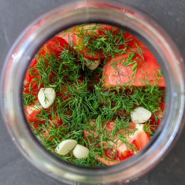 tomatoes and herbs in a jar