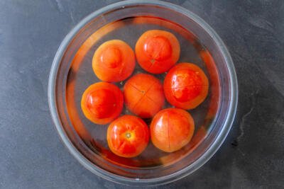 Tomatoes in a bowl with boiled water