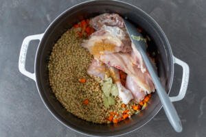 Lentil, chicken and veggies in a pot with bay leaves