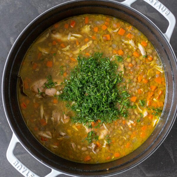 Chicken lentil soup in a pot with dill