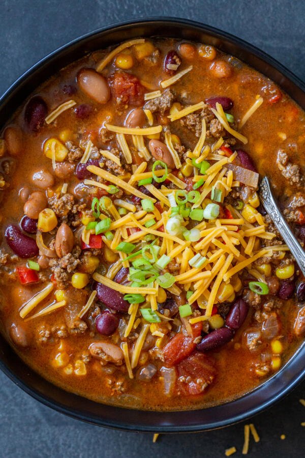 Instant Pot chili in a bowl with cheese and green onions