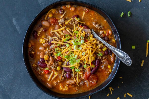 Instant Pot chili in a bowl with cheese and green onions