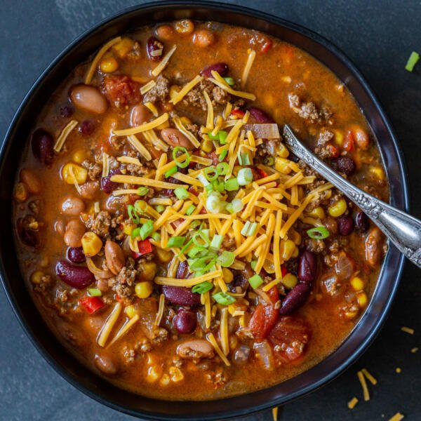 Instant Pot chili in a bowl with cheese and green onions