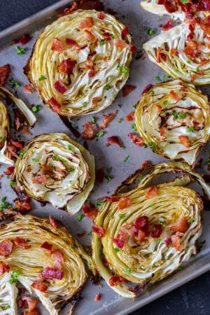 crispy roasted cabbage steaks on a pan with bacon